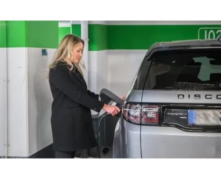 Une femme recharge son véhicule